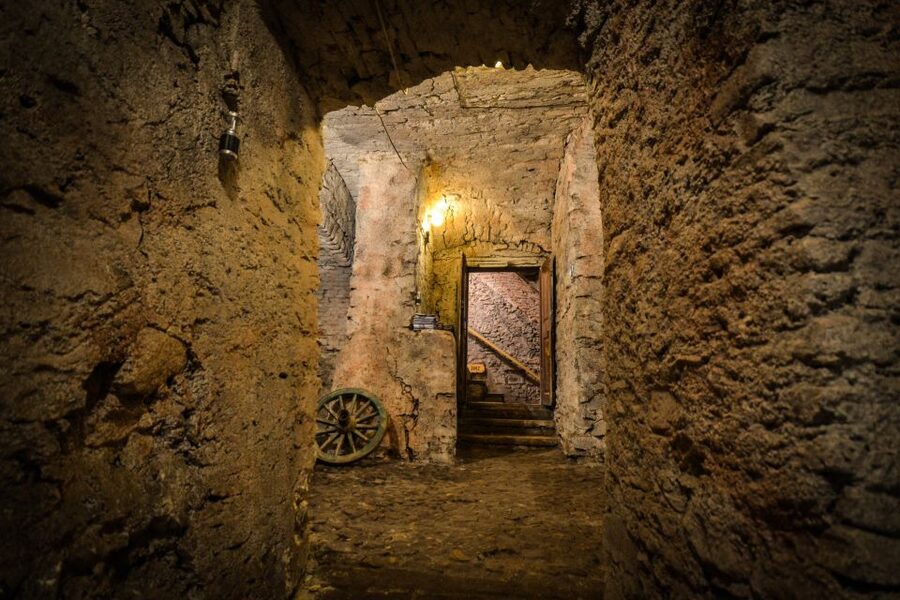 Prague: Ghosts, Legends, Medieval Underground & Dungeon Tour - Entering the candlelit dungeon